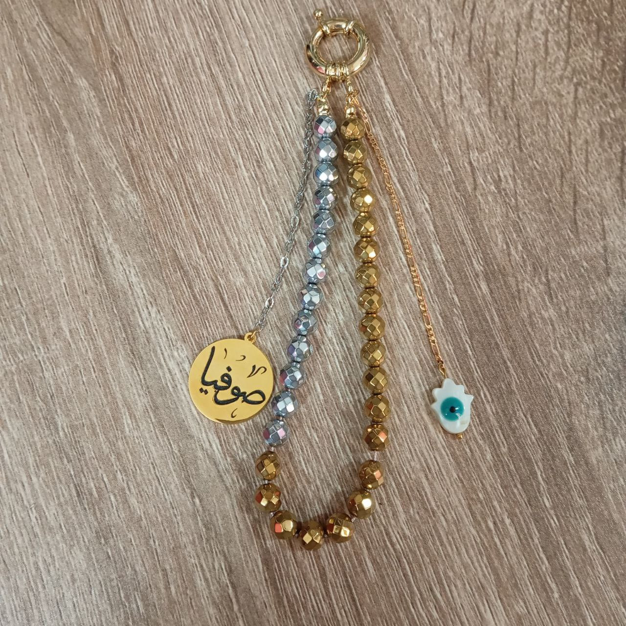 Three beaded keychains with different designs on a wooden surface