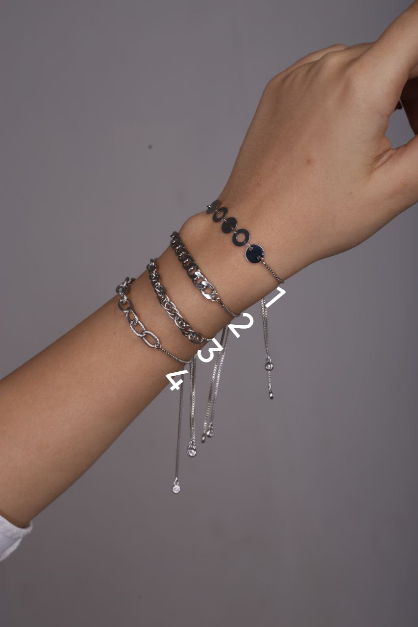 Hand wearing multiple bracelets on a gray background