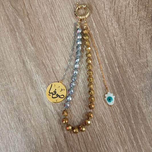 Three beaded keychains with different designs on a wooden surface