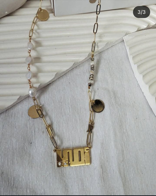 Gold necklace with beads on a textured surface