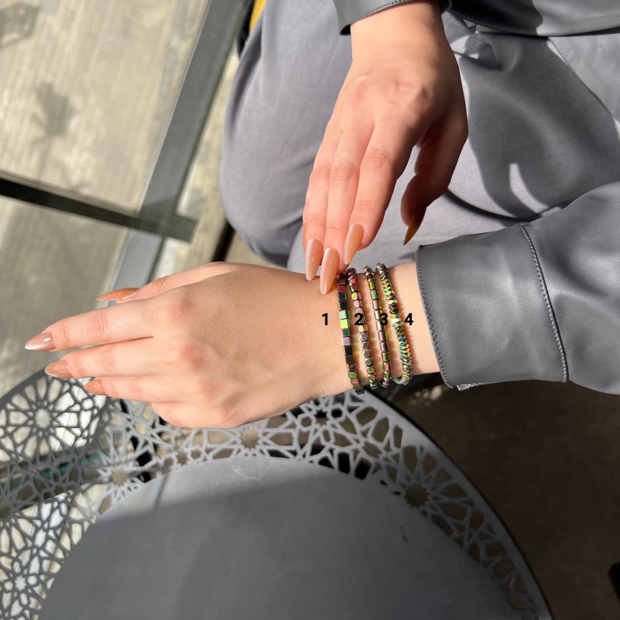 Person wearing colorful bracelets on a metal chair