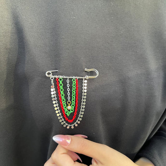 Colorful chain brooch on a dark fabric background