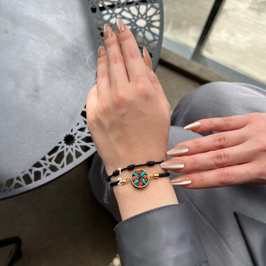 Hand wearing a colorful bracelet with a decorative background