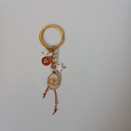 Gold keychain with charms on a light gray background