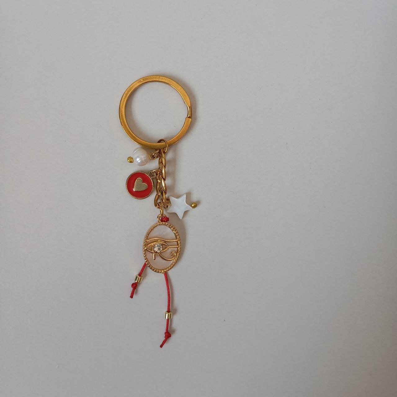 Gold keychain with charms on a light gray background