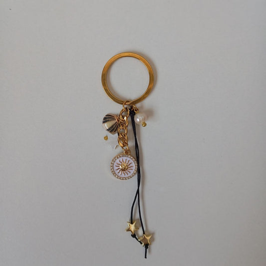 Gold keychain with charms on a gray background