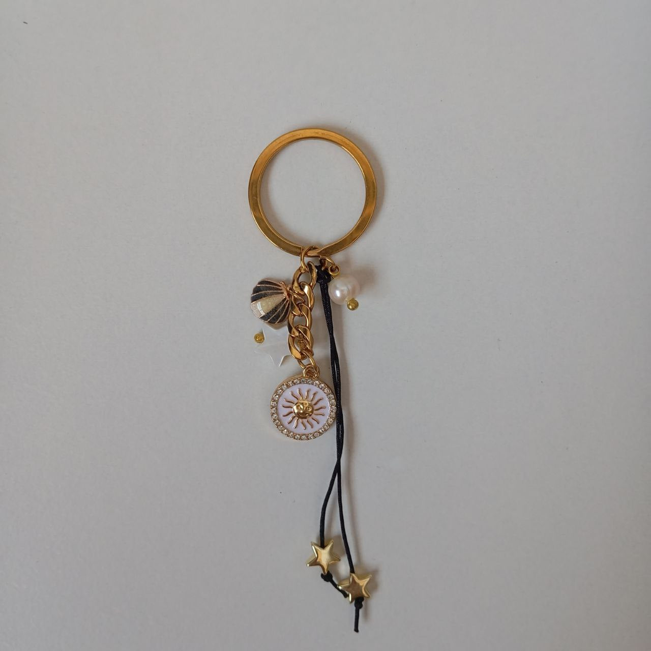 Gold keychain with charms on a gray background
